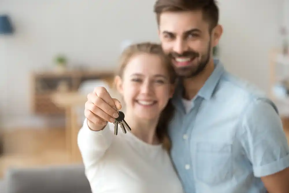 young couple with home keys